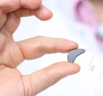 open fit hearing aid held in finger tips